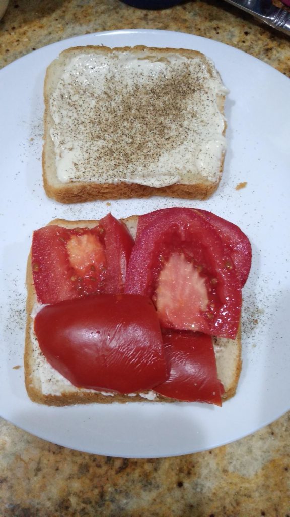 white bread with mayo black pepper and tomato